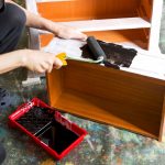 Painting a piece of furniture in black.