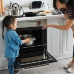 Putting stainless steel pot in an oven.